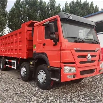 Yellow dump truck filled with quarry stones